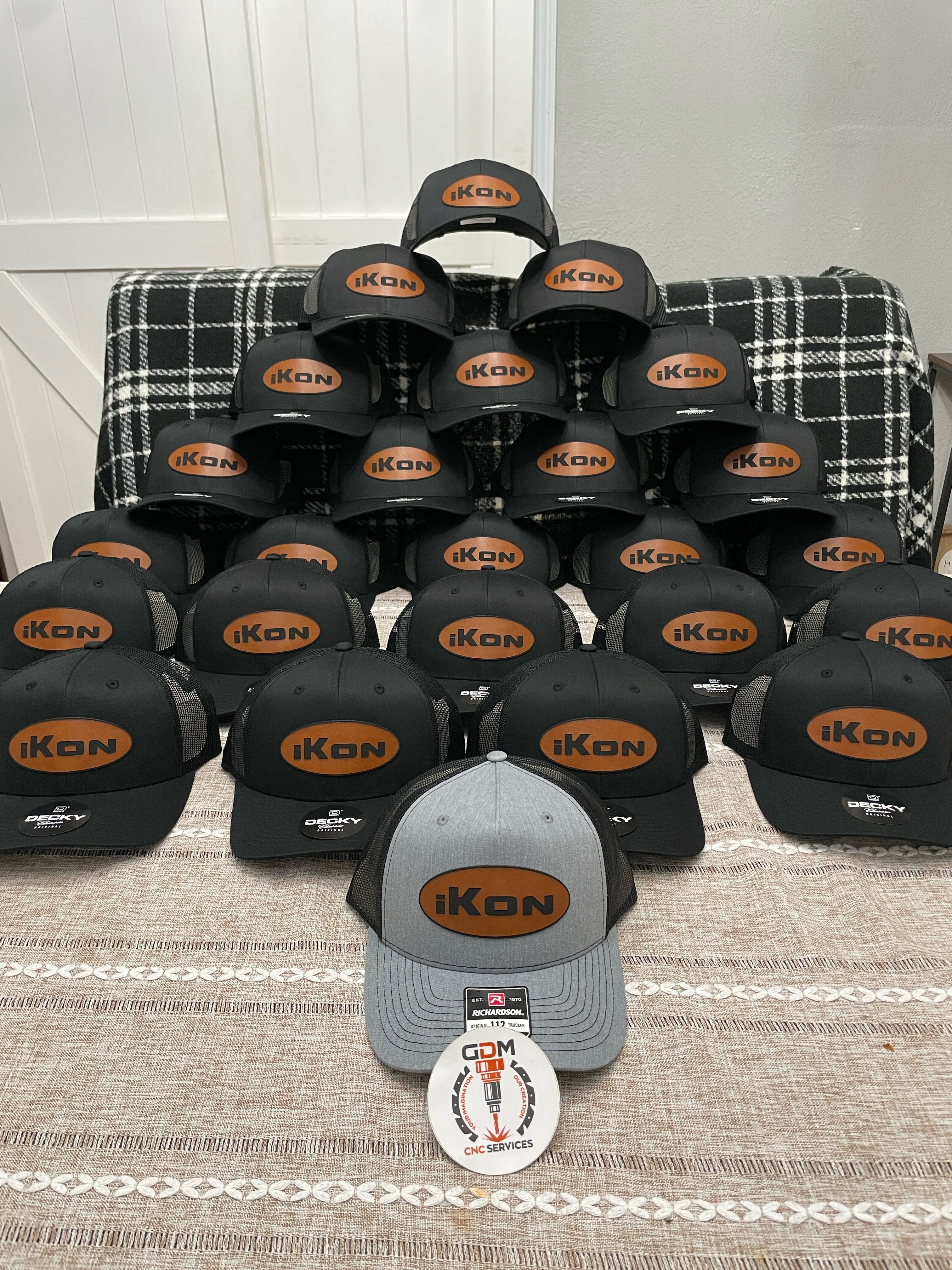 iKon bulk order — black trucker hats with leather oval patch